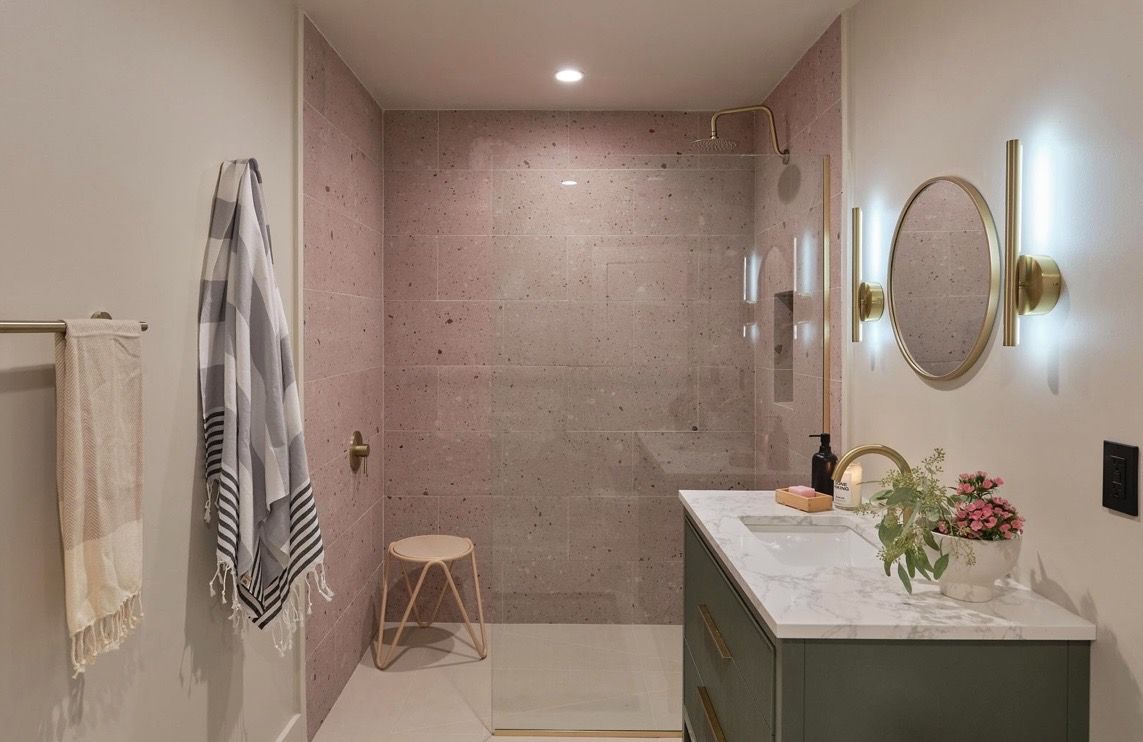 Bathroom with blush concrete shower and brass fixtures