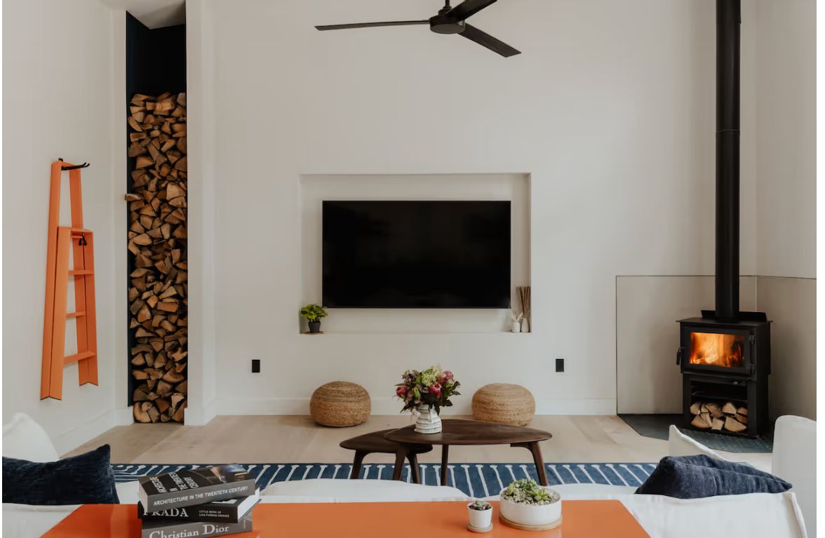 Living room with wood stove and stacked firewood